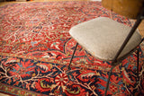 Vibrant dark blue border with oversize scrolling palmettes on a vintage Persian Ahar rug.