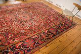 Prominent dark blue border of the vintage Ahar rug with scrolling leaves and palmettes.