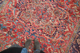 Vintage Heriz carpet's curved linear design in cherry red, navy blue, and saffron with feet.
