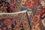 Detail of vintage Heriz rug: hand-knotted curvilinear pattern, red, blue, gold, and ivory fringe.