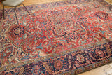 Navy blue border with intricate curvilinear motifs and madder red details on a vintage Heriz rug.