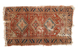 Antique Heriz hand-knotted rug, copper field with triple diamond medallions, navy borders, and worn pile.