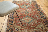 Navy and beige serrated leaf border detail on a worn antique Heriz rug.