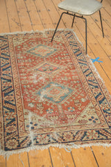 Tattered corner of antique Heriz rug, with exposed foundation and navy palmette border.