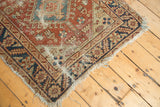 Worn fringe, serrated leaf and palmette border, copper and navy antique Heriz rug.
