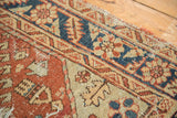 Textured copper field and navy serrated leaf palmette border on an antique Heriz rug.