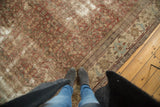 Distressed antique Mahal carpet section with copper Herati design and a decorative beige border.