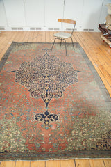 Madder root red floral field, navy medallion detail, and visible hard wear on antique Farahan rug.
