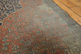 Visible hard wear on madder root red floral field and navy border of antique Farahan rug.