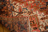 Heriz carpet showing geometric red, blue, ivory pattern and hand-knotted foundation.
