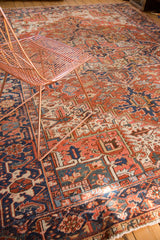Rich red and navy geometric patterns of a hand-knotted vintage Heriz carpet.