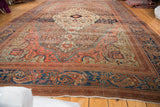 Antique Farahan carpet's intricate blue border, blush floral patterns, and frayed end.