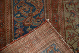 Antique Farahan rug's hand-knotted foundation, frayed edge, and vivid blue, blush, bronze motifs.