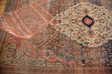 Decorative curvilinear pattern with blush, blue, and wooded tones on an antique Farahan rug.