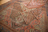Antique Farahan carpet's rare copper, blush, and blue palette with intricate floral motifs and rich patina.