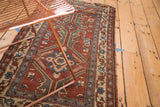 Worn edge and floral border of a vintage Turkish rug in copper, sky blue, and antique ivory.