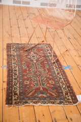 Small vintage Turkish rug with copper and green asymmetric motifs shown for scale.