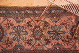Blush, indigo, and sky blue mina khani floral motifs on a vintage Lilihan rug.