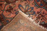 Frayed fringe and hand-knotted foundation of a vintage Lilihan rug with blush and blue pile.