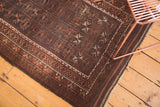Vintage Belouch rug corner showing geometric starbursts, intricate borders, and rich aged patina.