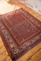 Vintage Hamadan rug side with abrashed red field, geometric borders, and storied patina.