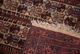 Vintage Belouch rug with rich red geometric border, light ivory fringe, and patterned field.