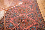 Intricate geometric patterns on a faded red vintage North West rug with sky blue accents.