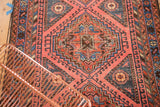 Intricate geometric medallion with sky blue and faded teal patterns on a distressed blush field.