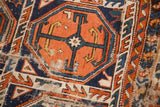 Tangerine orange gul motif with blue geometric pattern and distressed pile, revealing exposed foundation.