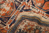 Antique Caucasian rug showing its tattered edge, exposed foundation, and geometric gul motif.
