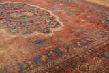 Antique Bijar carpet corner: rich brick red field and intricate navy, gold patterned borders with patina.