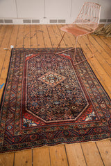 Engelas rug with a partial diamond medallion, brick red borders, and navy Herati field.