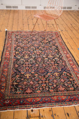 Distressed dark navy field and intricate garrus designs on a vintage Mahal rug corner.