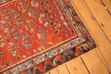 Corner close-up of antique Hamadan runner, cherry red diamond lattice field, and patterned border.