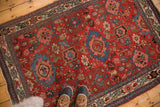 Antique Harshang Bijar rug corner: cherry red field, diminutive garrus arabesques, elongated leaf border.