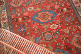 Vibrant cherry red ground of an antique Harshang Bijar rug with diminutive blue and blush arabesques.