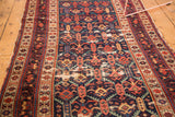 Antique Caucasian runner's navy field with blossoming pomegranate and serrated leaf design. Visible foundation.