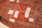 Antique Anatolian runner with bold red geometric patterns, natural dyes, and white patches.