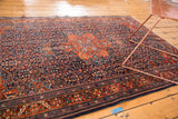 Finely woven vintage Farahan Sarouk rug corner with brick red border, intricate navy, ivory motifs.