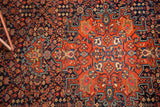 Vintage Farahan Sarouk rug's brick red medallion and intricate navy blue henna field.