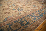Rich blue main border and beige field with floral palmettes on vintage Tabriz.