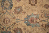 Detail of the distressed floral tendril and palmette design in beige, brown, and blue tones.