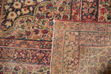 Hand-knotted foundation and cochineal red millefleur design on antique Kerman carpet.