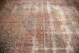 Antique Kerman panel carpet's repeating lattice pattern with faded cochineal red and navy.