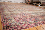 Intricate cochineal red borders and navy millefleur panel design of an antique Kerman carpet.