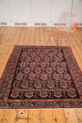 Vintage Malayer rug corner, dark indigo field with ivory, blush floral botehs and patterned border.