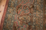 Hand-knotted vintage Persian carpet detail with aged blush, brown, and teal floral motifs.