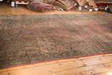 Traditional vintage Persian Meshed carpet with aged blush floral field and dark brown border.