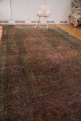 Close-up of vintage hand knotted carpet border with floral design and aged blush raspberry tones.