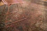 Patinated floral field of a vintage Persian rug with blush raspberry, brown, and teal.